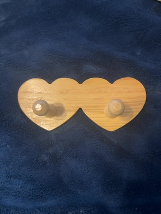 vintage wooden wall-mounted peg rack featuring two heart-shaped cutouts
