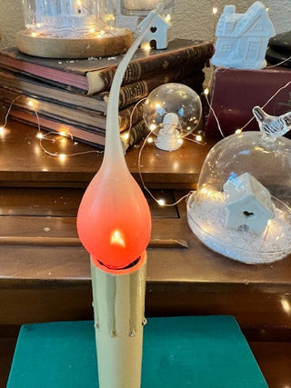 Antique candlestick with flickering lightbulb.