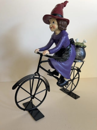 Cute Witch Riding a Metal Bike with Cauldron