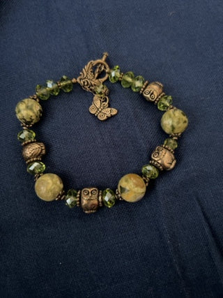 Green beaded bracelet with metal butterfly