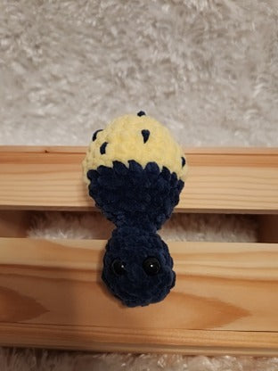 Mushroom Fidget Popper: Crocheted yellow, navy. Fidget pops in and out.