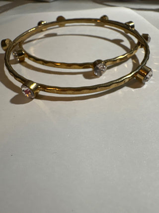 2 gold colored bangles with clear stones