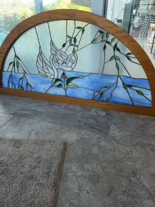 Stained glass window arch framed swans