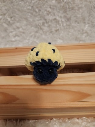 Mushroom Fidget Popper: Crocheted yellow, navy. Fidget pops in and out.