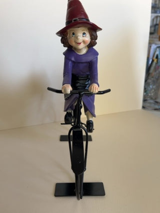 Cute Witch Riding a Metal Bike with Cauldron