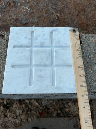 Tic-Tac-Toe set features a white marble base & wood playing pieces