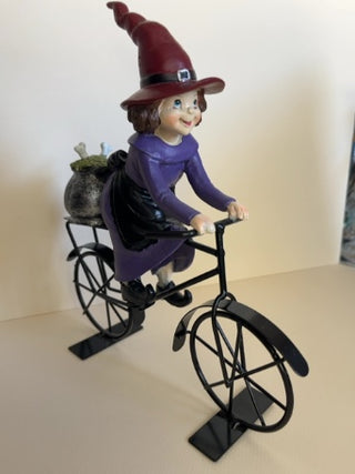 Cute Witch Riding a Metal Bike with Cauldron
