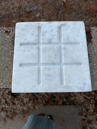 Tic-Tac-Toe set features a white marble base & wood playing pieces