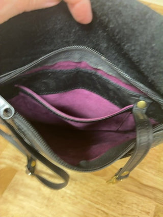 "Michelle Barclay Boutique Designer Crossbody Bag. Genuine thick tooled black leather with signature purple suede interior lining. Excellent condition!"