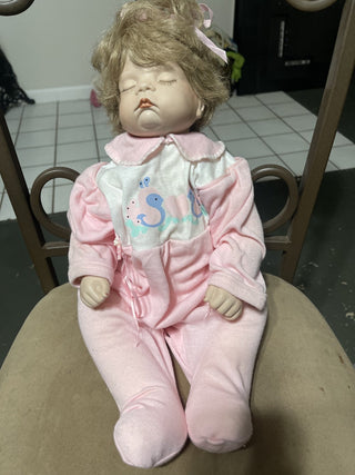 baby doll in pink onesie, eyes closed rsv