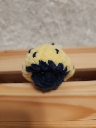 Mushroom Fidget Popper: Crocheted yellow, navy. Fidget pops in and out.
