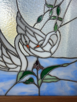 Stained glass window arch framed swans