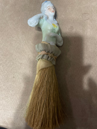 large whisk  broom woman with green shirt and ruffle dress
