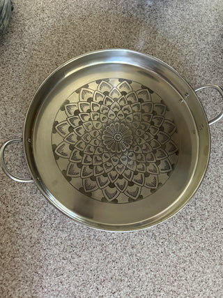 Silver metal serving tray with engraved mandala in the center
