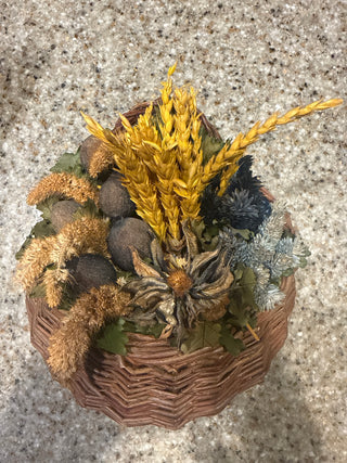 rustic autumn wall basket filled with dried wheat, seed pods, and foliage.