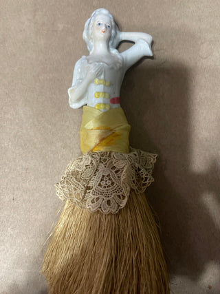 large whisk  broom, woman with yellow ruffle dress