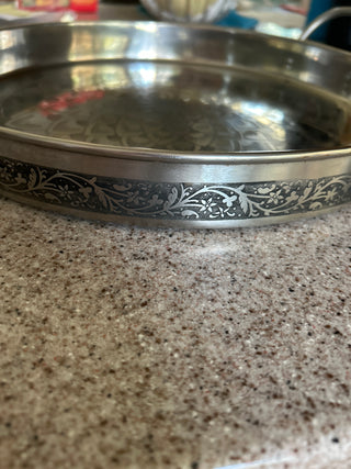 Silver metal serving tray with engraved mandala in the center